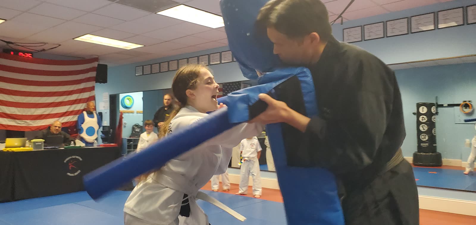 Instructor holding the tackling dummy during a teen self-defense drill